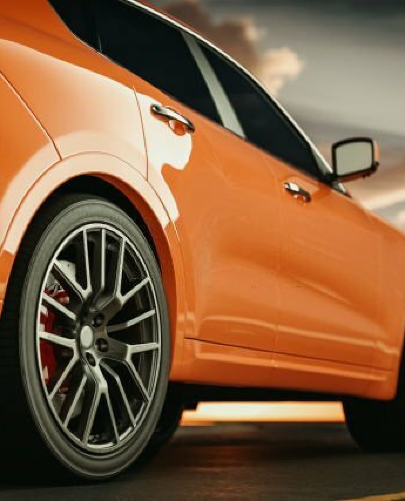 Close-up side view of an orange luxury sports car